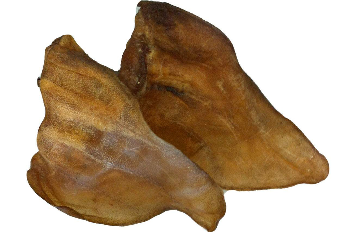 Two natural dried cow ears dog treats on white background